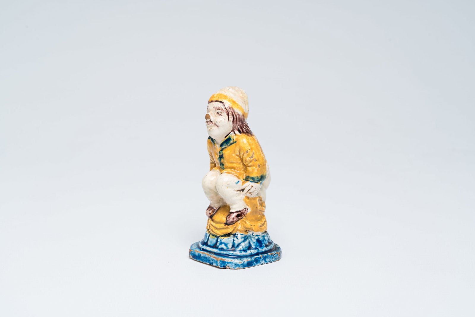 A French polychrome faience figure of a pooping man or 'kakkertje', 18th/19th C. (1 of 7)
