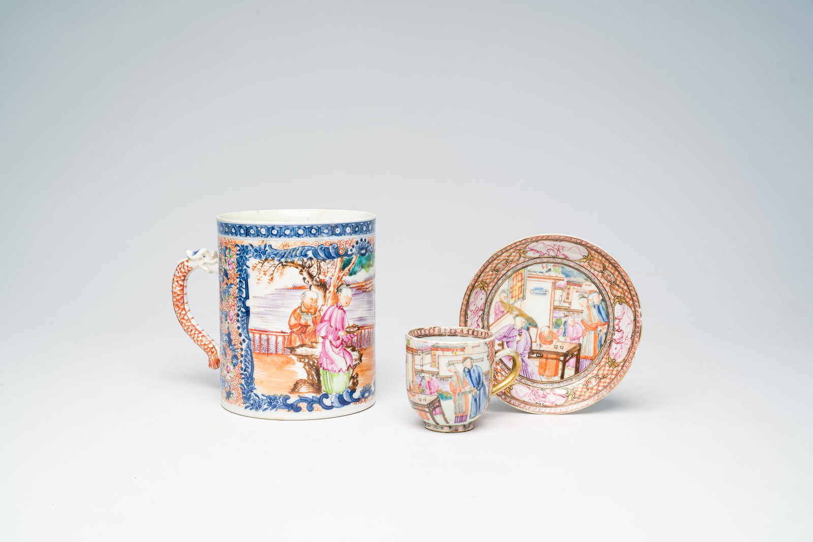 A Chinese famille rose 'Mandarin' mug, a cup and a saucer, Qianlong: H 13 cm - Dia.: 11 cm (the mug) Dia.: 12,2 cm (the saucer) H 6 cm - Dia.: 5,7 cm (the cup) Condition reports and high resolution pictures are available on our website at www.coronariauctions.com. Furt