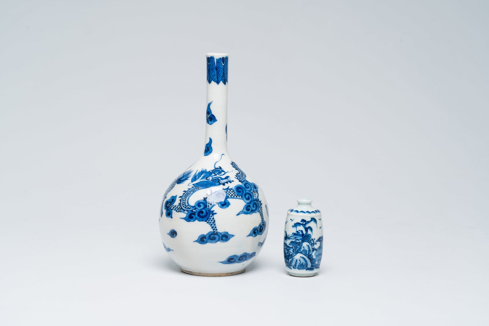 A Chinese blue and white Vietnamese market 'Bleu de Hue mythical animals' bottle vase and a: A Chinese blue and white Vietnamese market 'Bleu de Hue mythical animals' bottle vase and a 'landscape' snuff bottle, 19th/20th C. H 20,5 cm (the vase) H 7 cm (the snuff bottle) The vase with a yushan