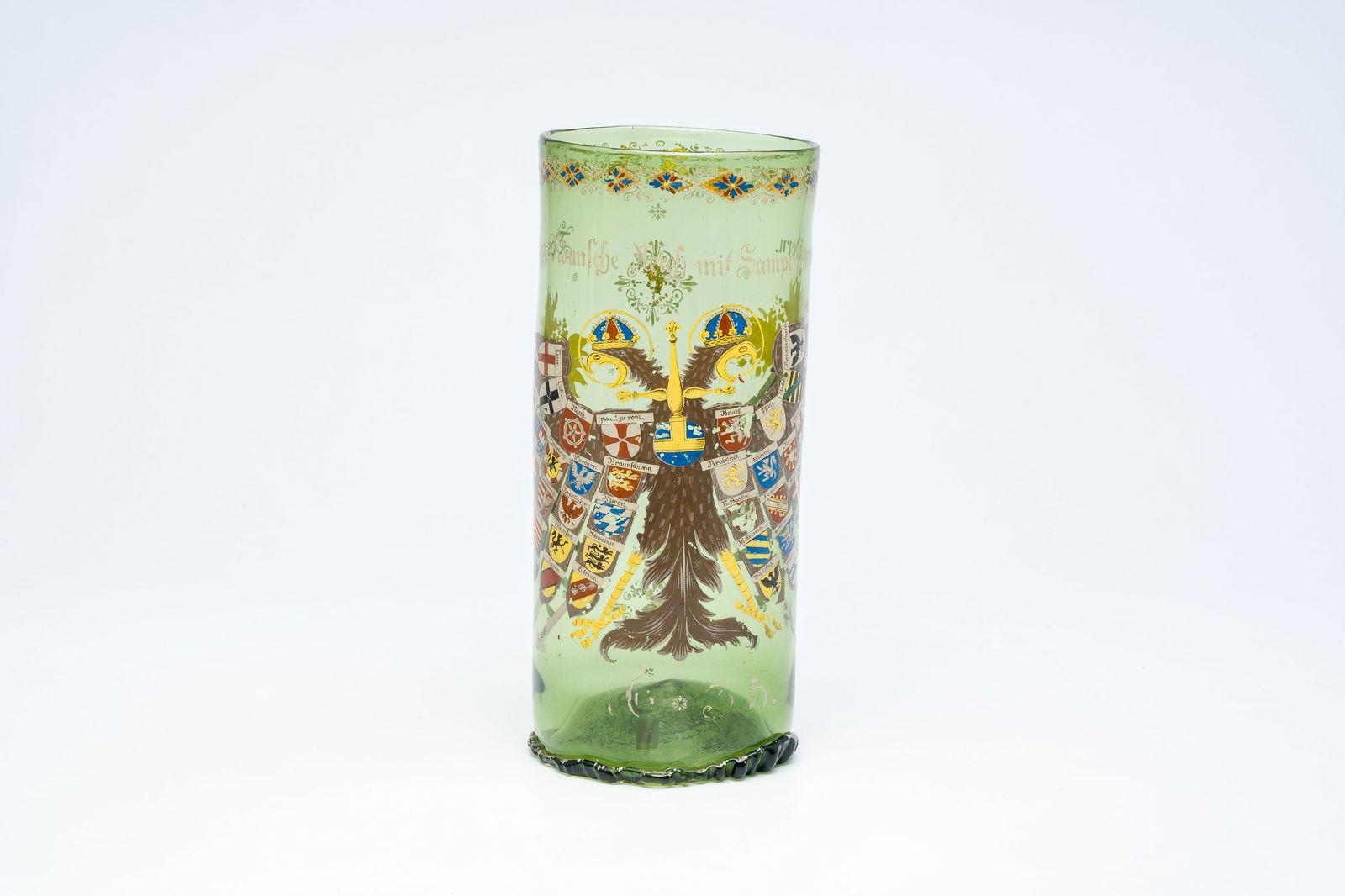 A German 'historismus' polychrome painted and gilt glass 'Reichsadler' humpen, probably Fritz: A German 'historismus' polychrome painted and gilt glass 'Reichsadler' humpen, probably Fritz Heckert, Petersdorf, dated 1635, late 19th C. H 38,8 cm Cylindrical with a kick-in base, supported on a fo