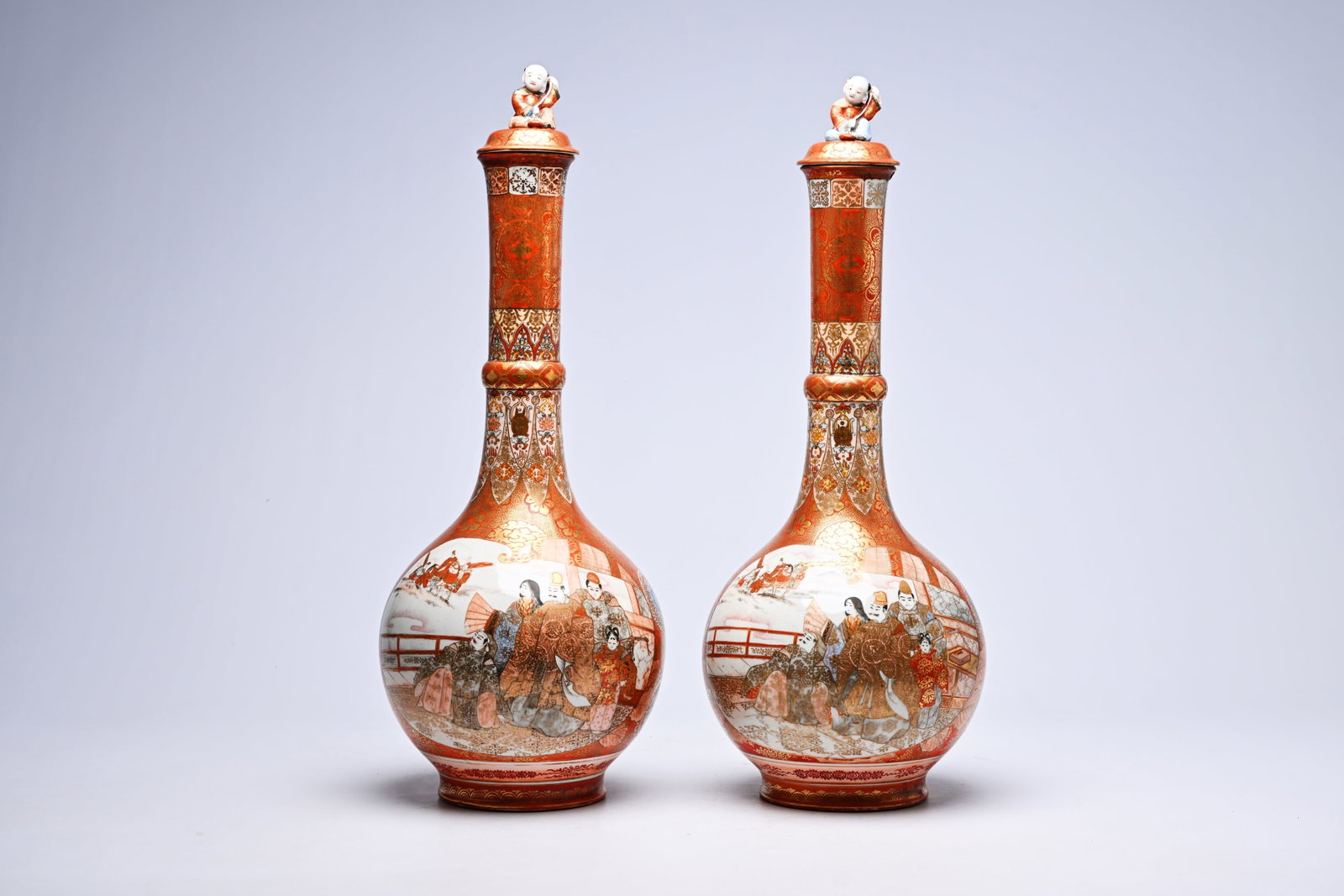 A pair of Japanese Kutani bottle-shaped vases and covers with a coot among blossoming branches and: A pair of Japanese Kutani bottle-shaped vases and covers with a coot among blossoming branches and figures on a terrace, Meiji, ca. 1900 H 68 cm