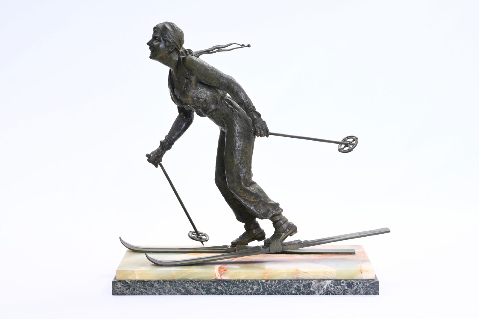 Sylvain Norga (1892-1968): A female skier, green patinated bronze on an onyx and vert de mer marble: Sylvain Norga (1892-1968): A female skier, green patinated bronze on an onyx and vert de mer marble base H 55,5 - L 57,5 - D 24 cm