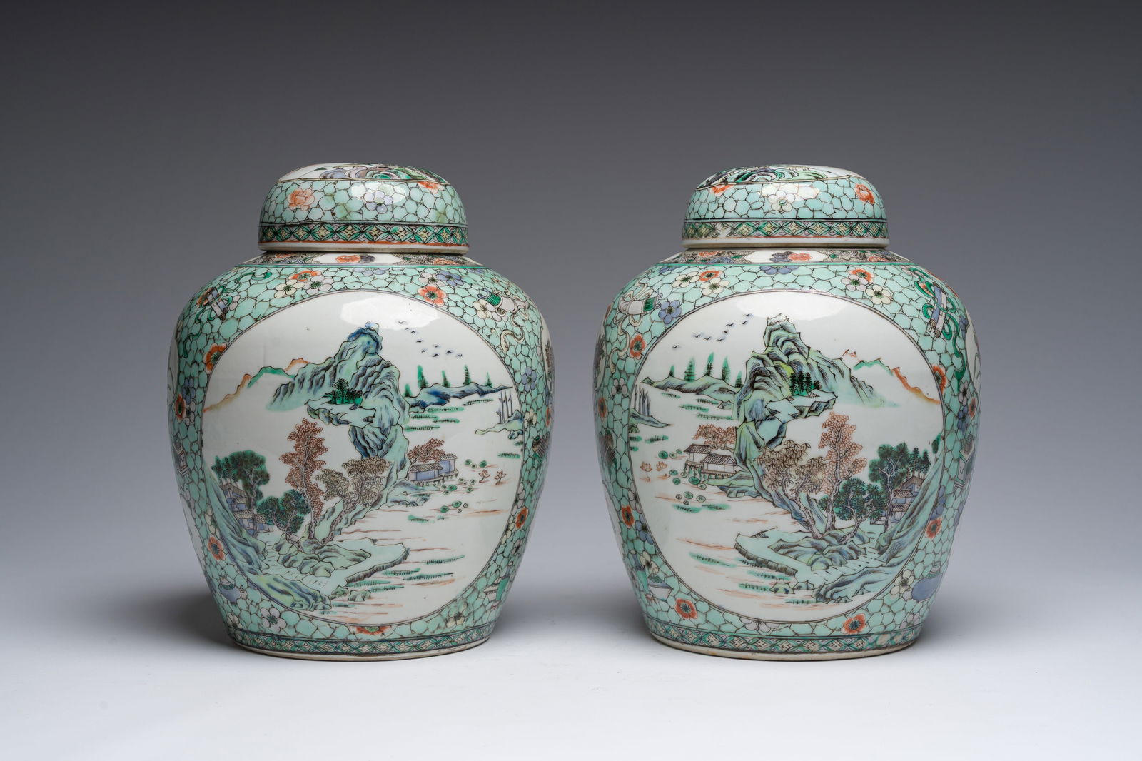 A pair of Chinese famille verte jars and covers with floral design, antiquities and river: A pair of Chinese famille verte jars and covers with floral design, antiquities and river landscapes, 19th C. H 27 cm