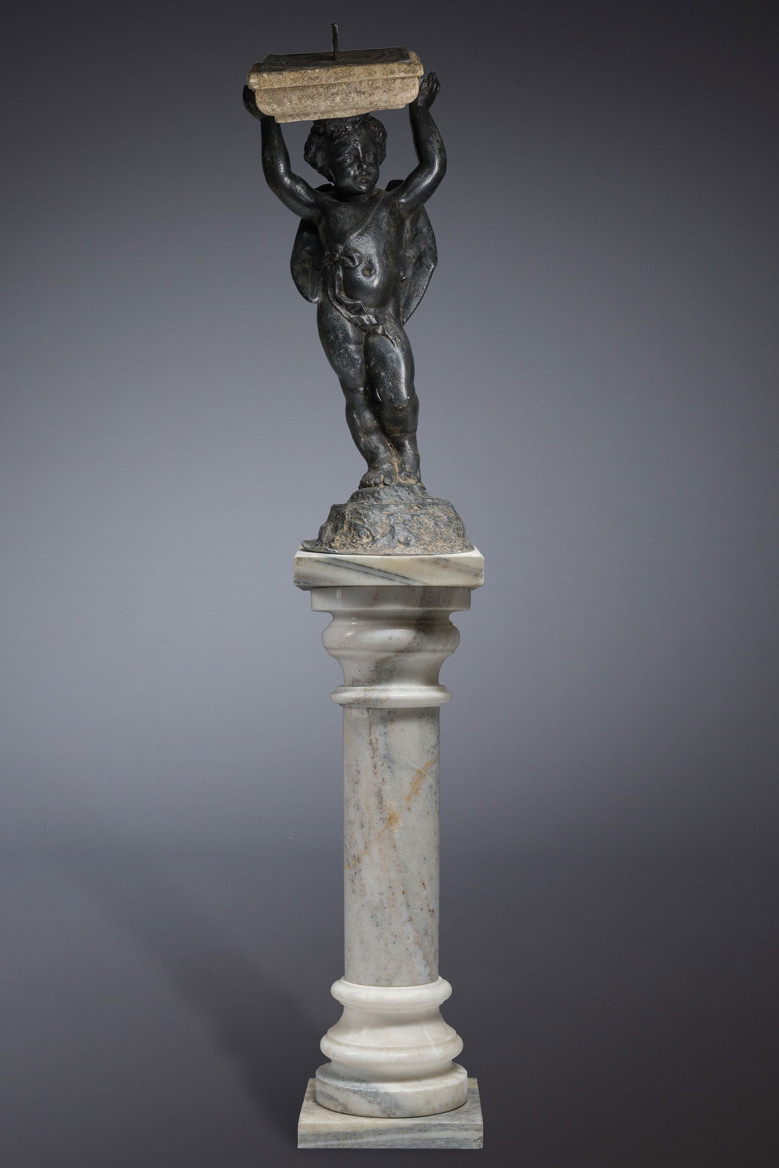 A lead garden statue of a putto holding a sundial, on a marble base, 19th C.: A lead garden statue of a putto holding a sundial, on a marble base, 19th C. H 159 - 76 cm(with and without base)