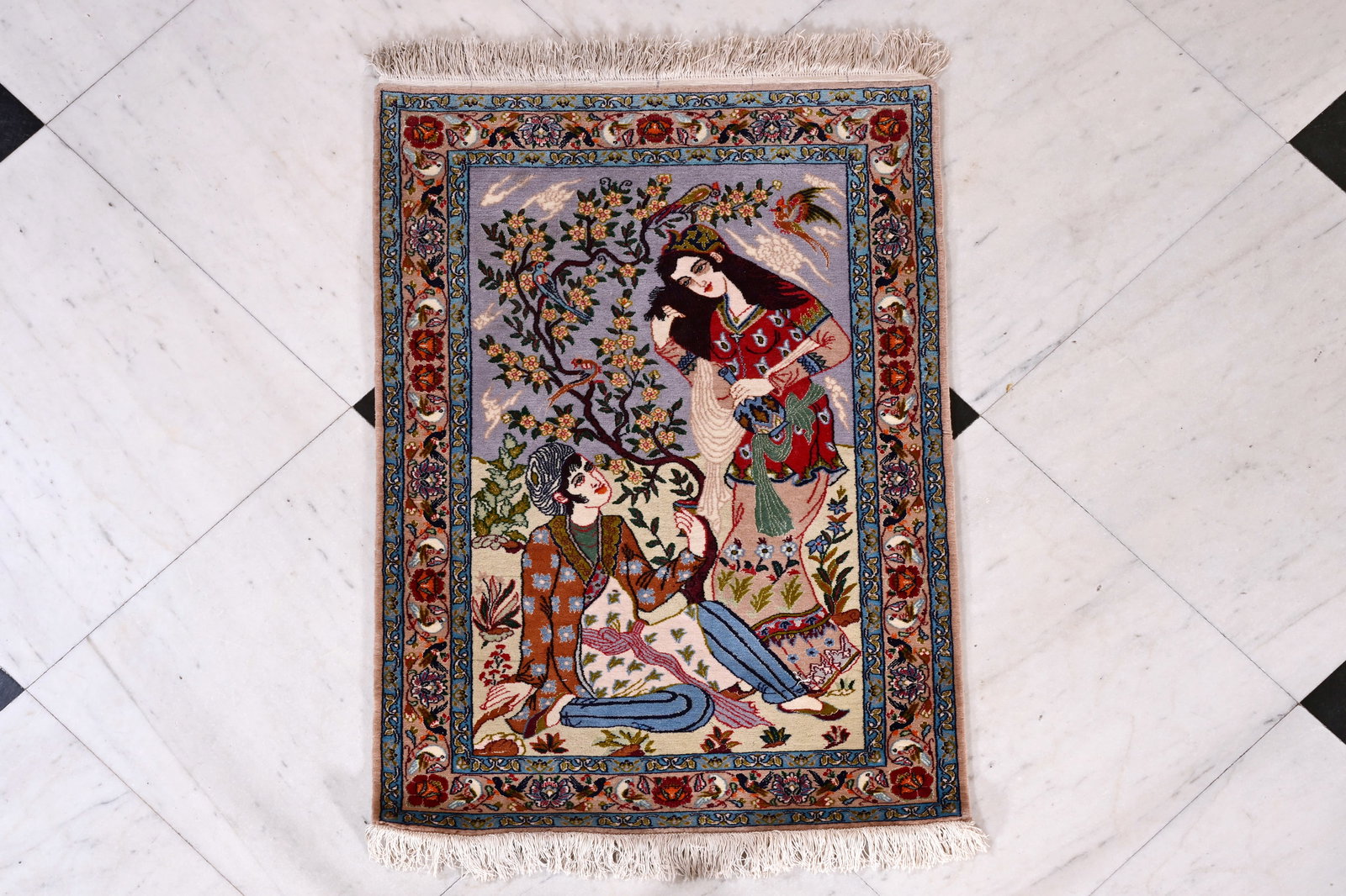 A Persian Isfahan rug with Layla and Majnun, wool on silk, 20th C.: A Persian Isfahan rug with Layla and Majnun, wool on silk, 20th C. 108 x 73,5 cm