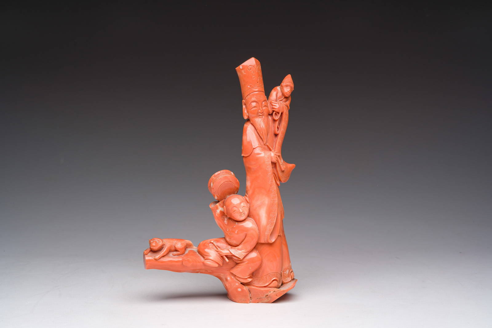 A Chinese red coral group with a scholar, his servant and a monkey, two-character mark, 19th C.