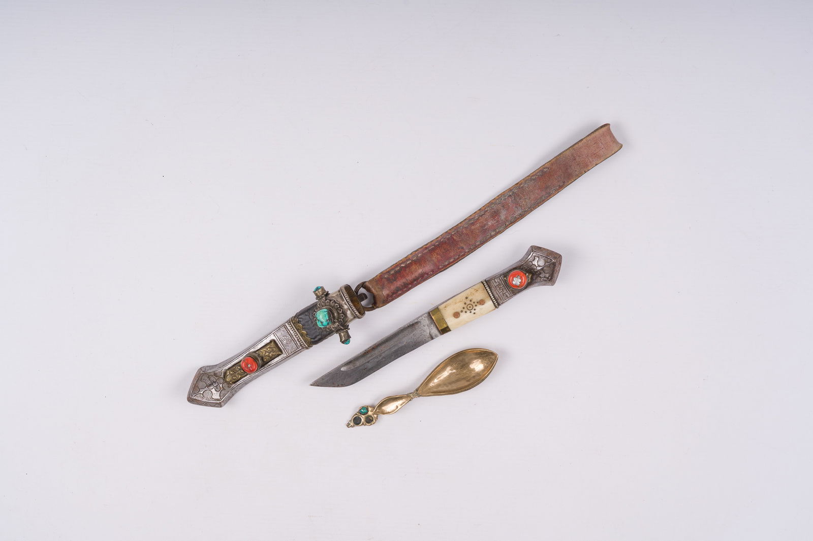 A Tibetan dagger with silver sheath and a turquoise-embellished copper spoon, 19th C.: A Tibetan dagger with silver sheath and a turquoise-embellished copper spoon, 19th C. L 12,5 cm (the spoon)L 20,5 cm (the knife, excl. the sheath)