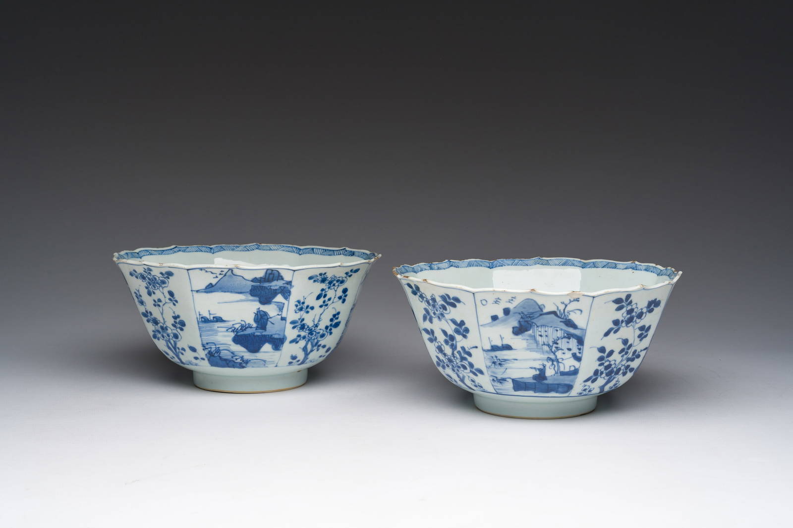 A pair of Chinese blue and white bowls with animated landscapes and floral design, Kangxi