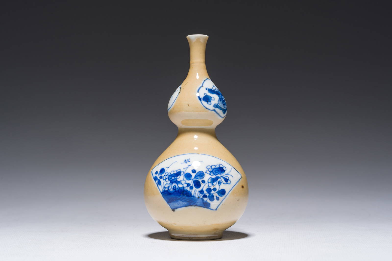 A Chinese blue and white café-au-lait-ground double gourd vase, Kangxi