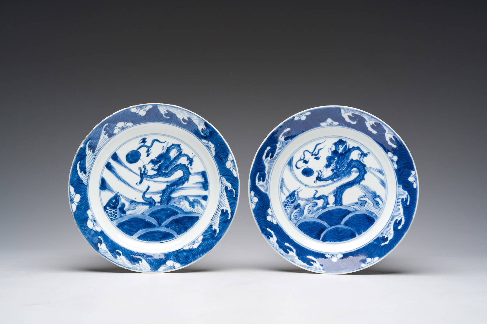 A pair of Chinese blue and white 'dragon and carp' plates, Kangxi
