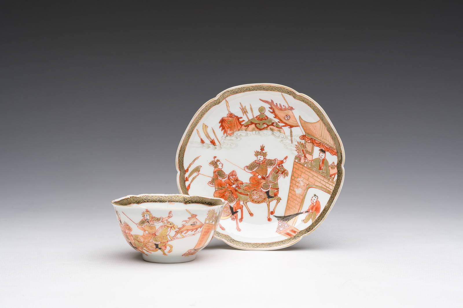 A Chinese iron-red and gilt 'Sanguozhi yanyi' cup and saucer, Yongzheng