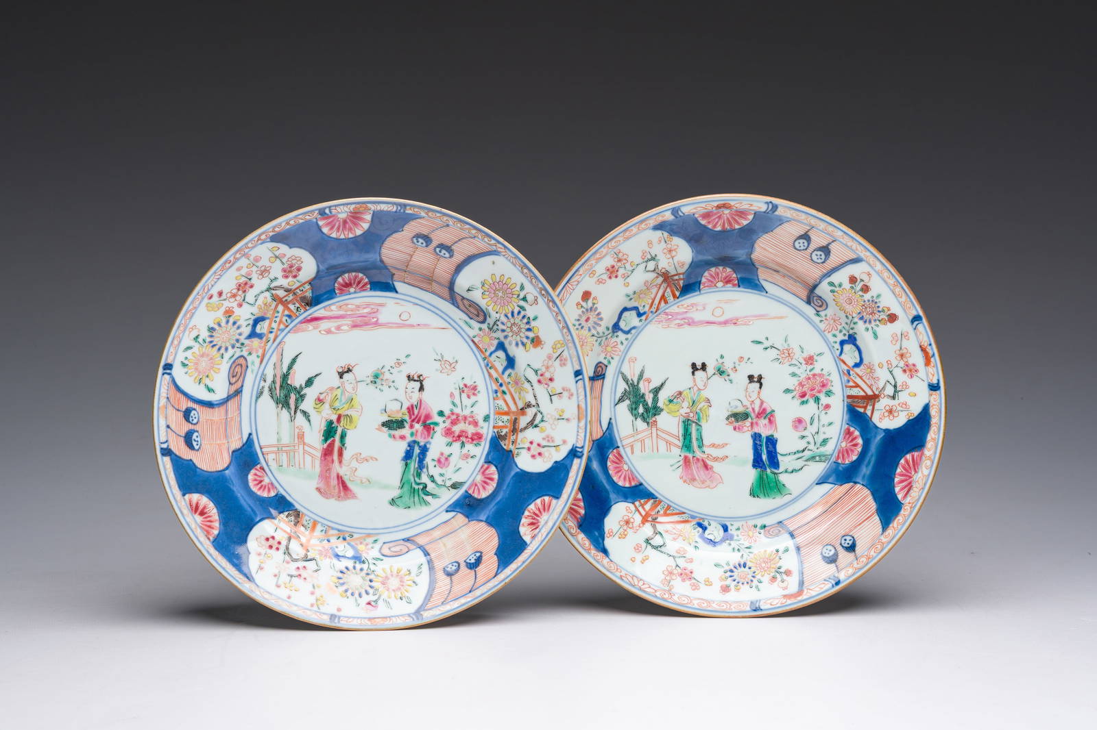A pair of Chinese rose-Imari plates with Magu and a servant in a palace garden, Yongzheng
