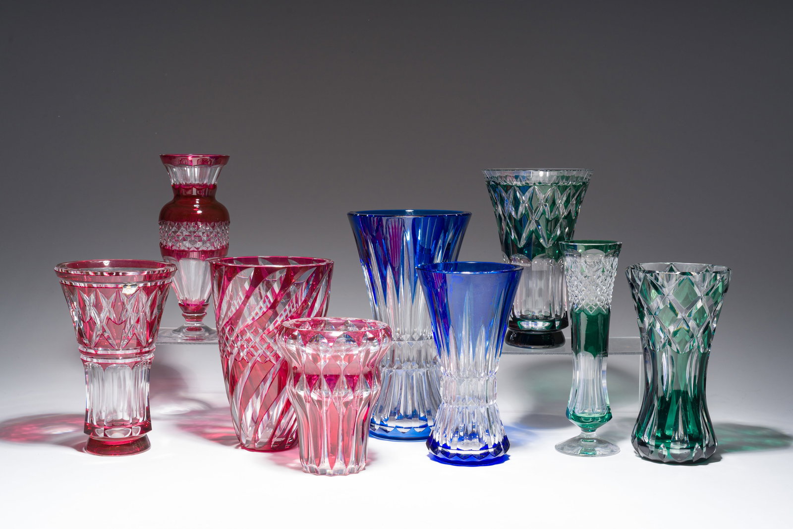 Nine partly coloured overlay cut crystal vases, Val Saint Lambert, Belgium, 20th C.: Nine partly coloured overlay cut crystal vases, Val Saint Lambert, Belgium, 20th C. H 25,5 - 15 cm (the tallest and the smallest vase)