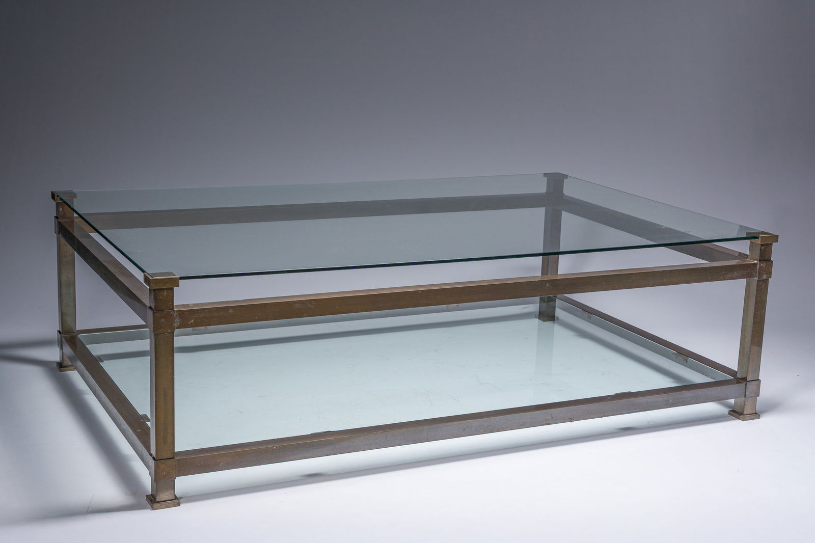 A rectangular patinated brass design coffee table with two glass shelfs, 2nd half 20th C. (1 of 4)