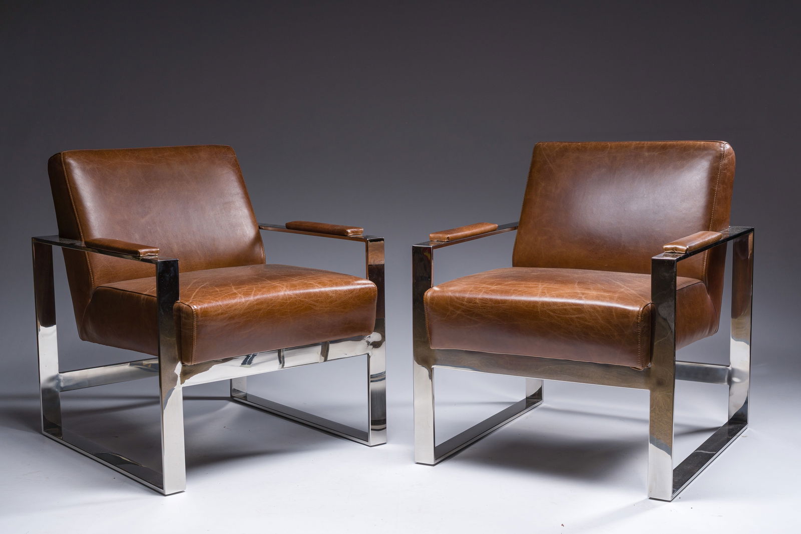 A pair of brown leather and chrome-plated steel 'Novatrend' armchairs, 20th C. (1 of 5)