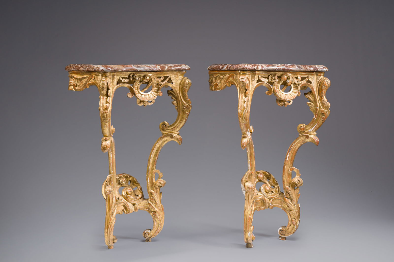 A pair of French carved gilt wooden Louis XV consoles with marble tops, 18th C.: A pair of French carved gilt wooden Louis XV consoles with marble tops, 18th C. H 87 - L 54 - D 33 cm