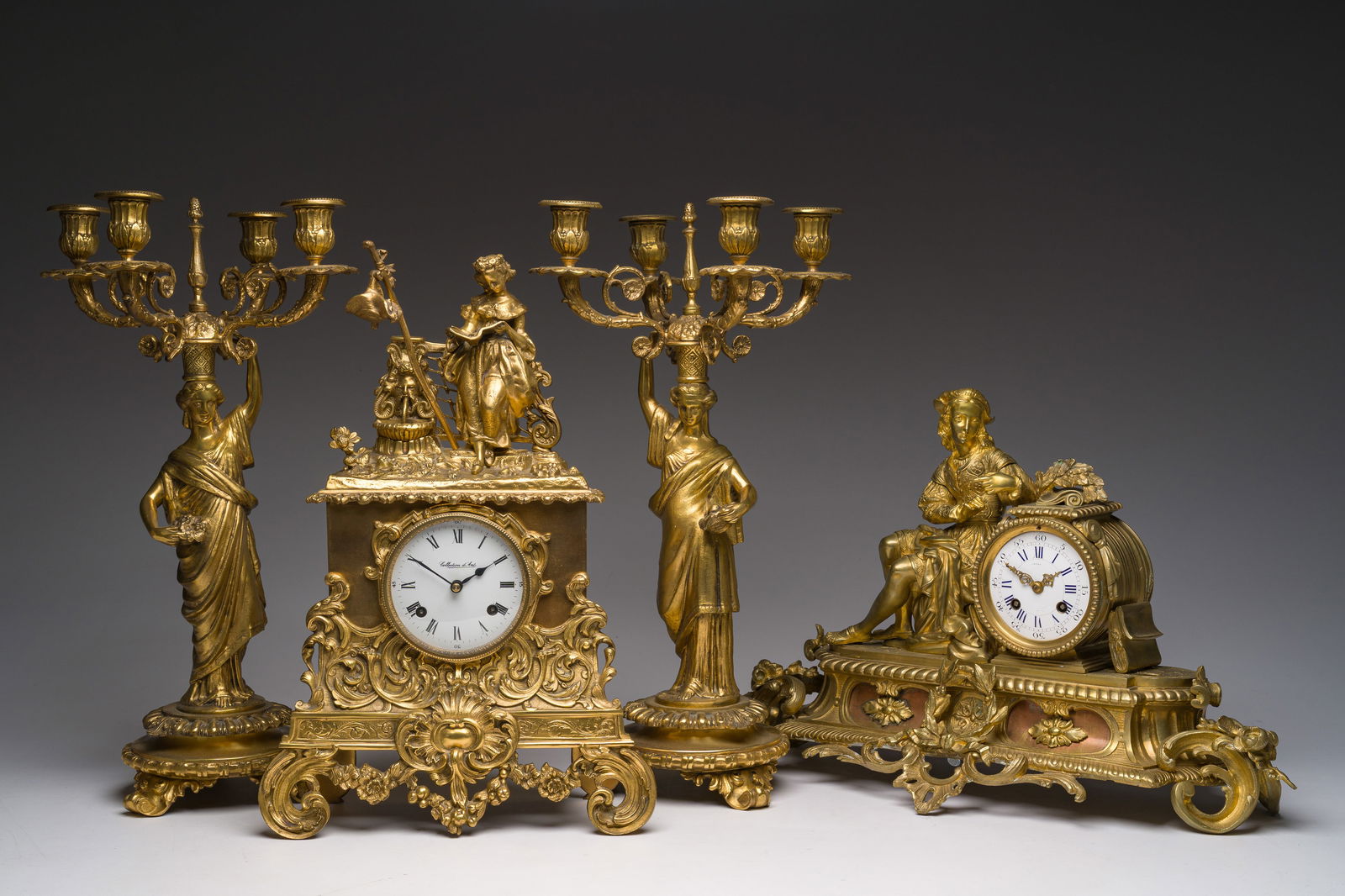 Two gilt bronze mantel clocks and a pair of four-light caryatid-shaped candlesticks, France and (1 of 14)