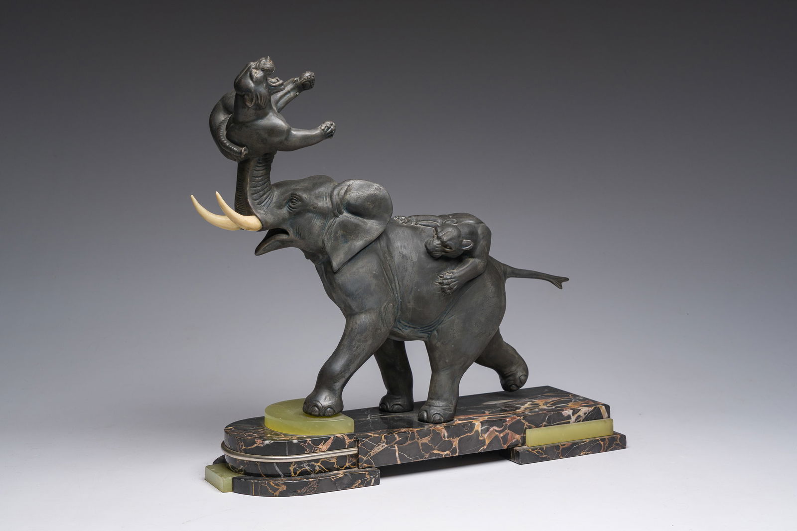 Illegibly signed: An elephant attacked by two tigers, zamak on a marble and onyx base, second: Illegibly signed: An elephant attacked by two tigers, zamak on a marble and onyx base, second quarter 20th C. H 41 - L 43 - D 14,5 cm