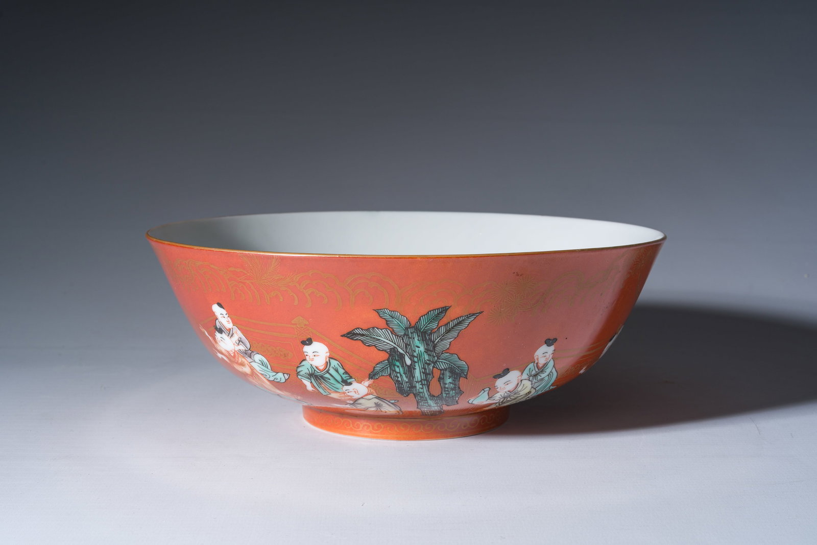 A Chinese coral-red ground famille verte bowl with playing boys, 19th/20th C. (1 of 7)