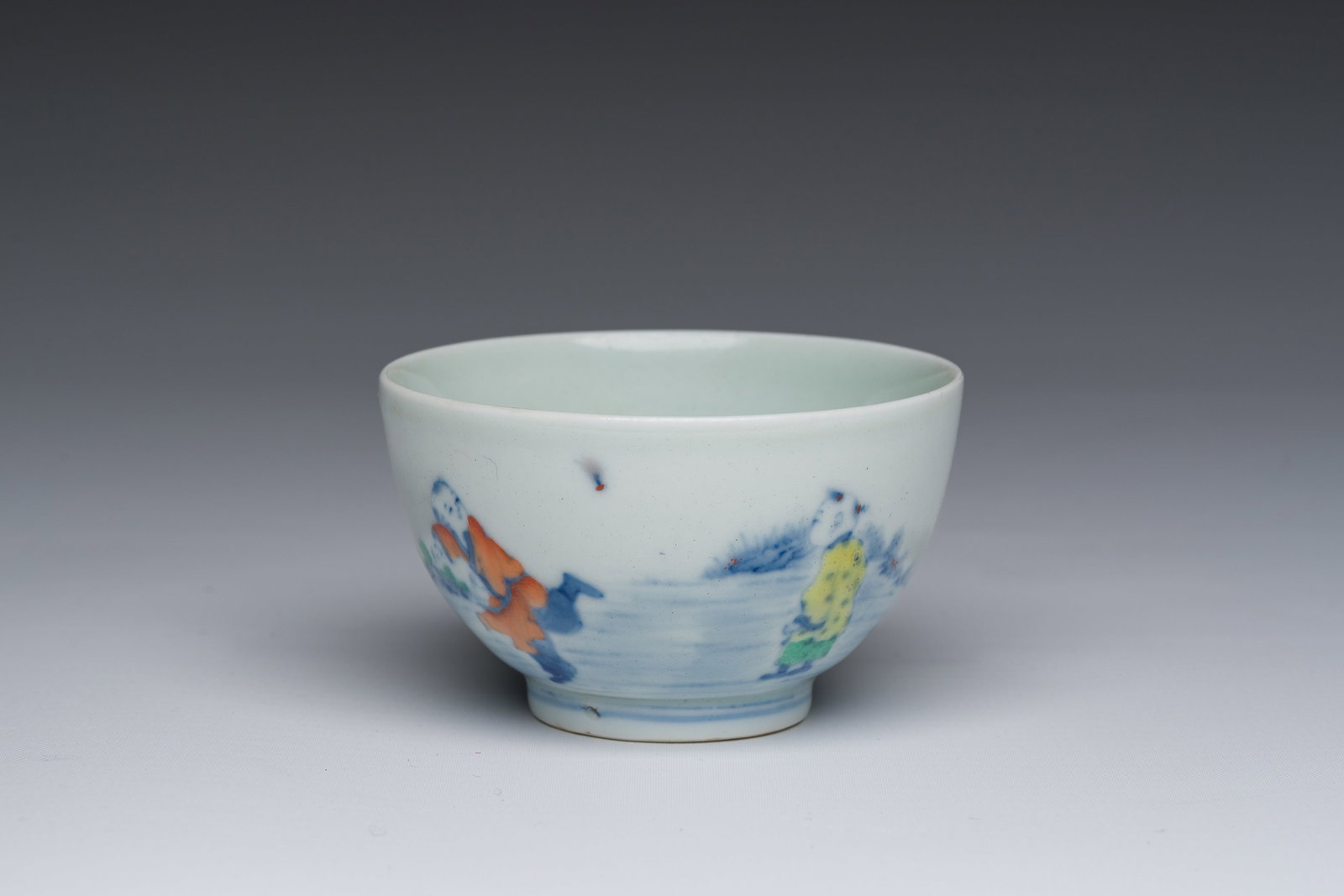 A Chinese doucai 'playing boys in a landscape' tea bowl, Wanli mark, 20th C. (1 of 8)