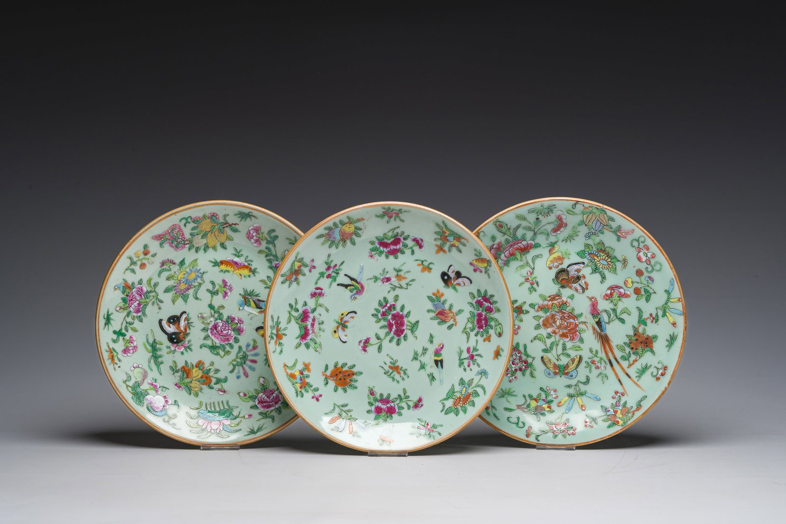 Three Chinese Canton famille rose celadon ground plates with birds, butterflies and flowers, 19th C. (1 of 3)