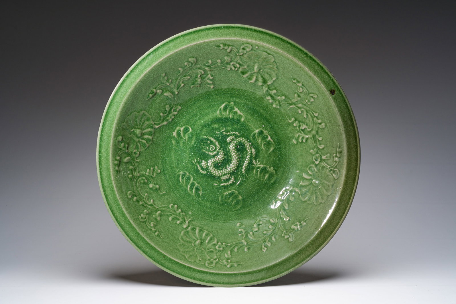 A massive Chinese or Vietnamese celadon glazed 'dragon' dish, 19th/20th C. (1 of 2)