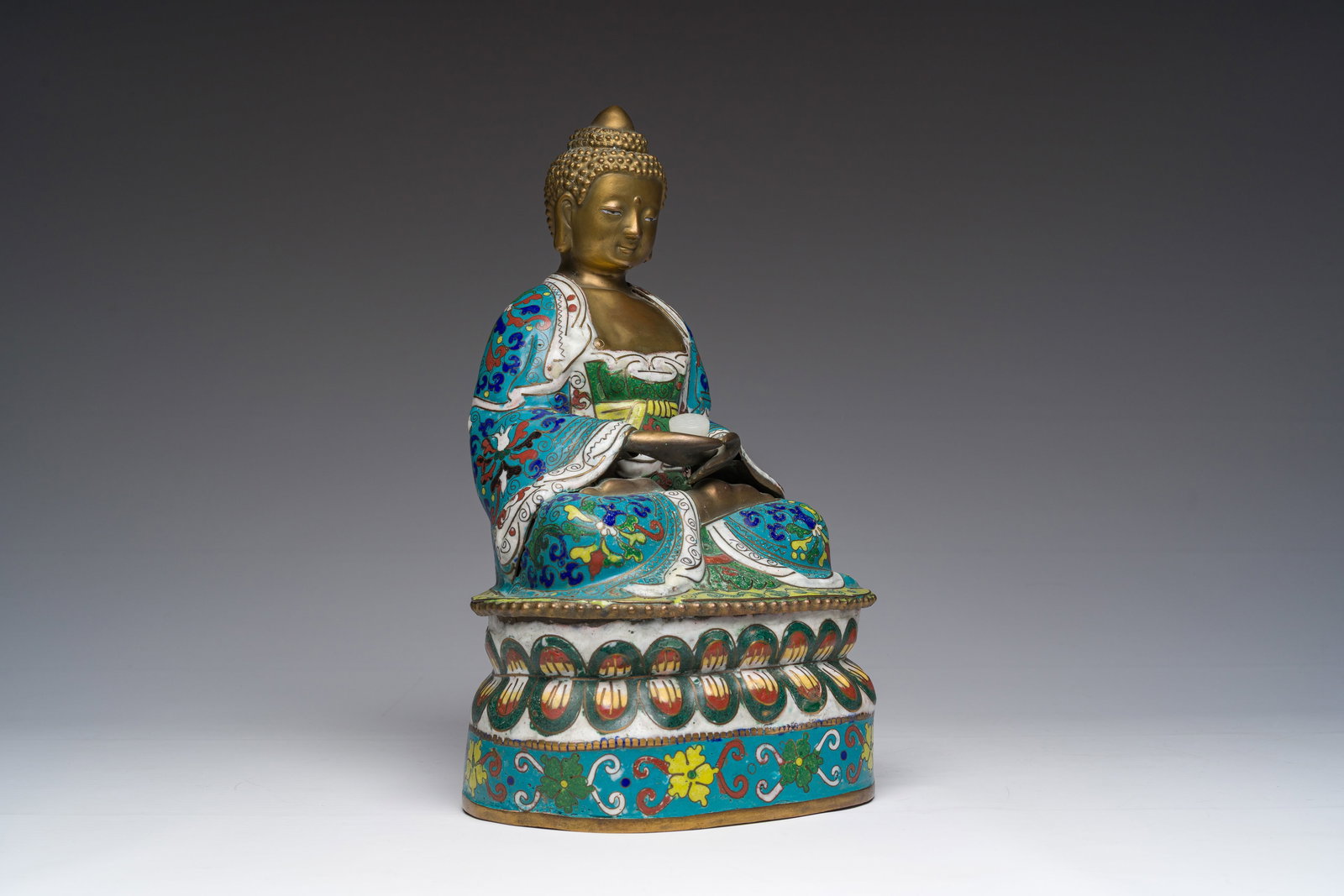 A Chinese cloisonne model of Buddha holding a white jade lotus flower, 20th C. (1 of 7)