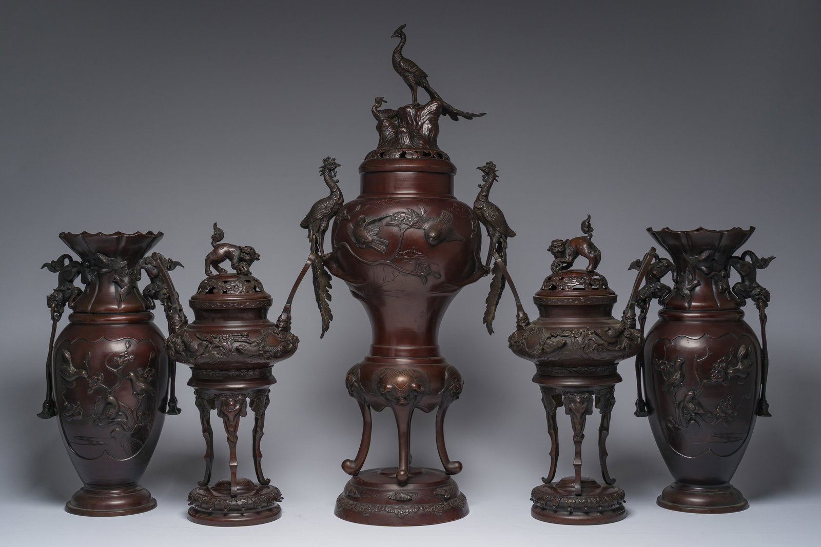 A Japanese five-piece bronze garniture with animal relief design, Meiji, 19th C.: A Japanese five-piece bronze garniture with animal relief design, Meiji, 19th C. H 89 - 52,5 cm (the largest and the smallest item)