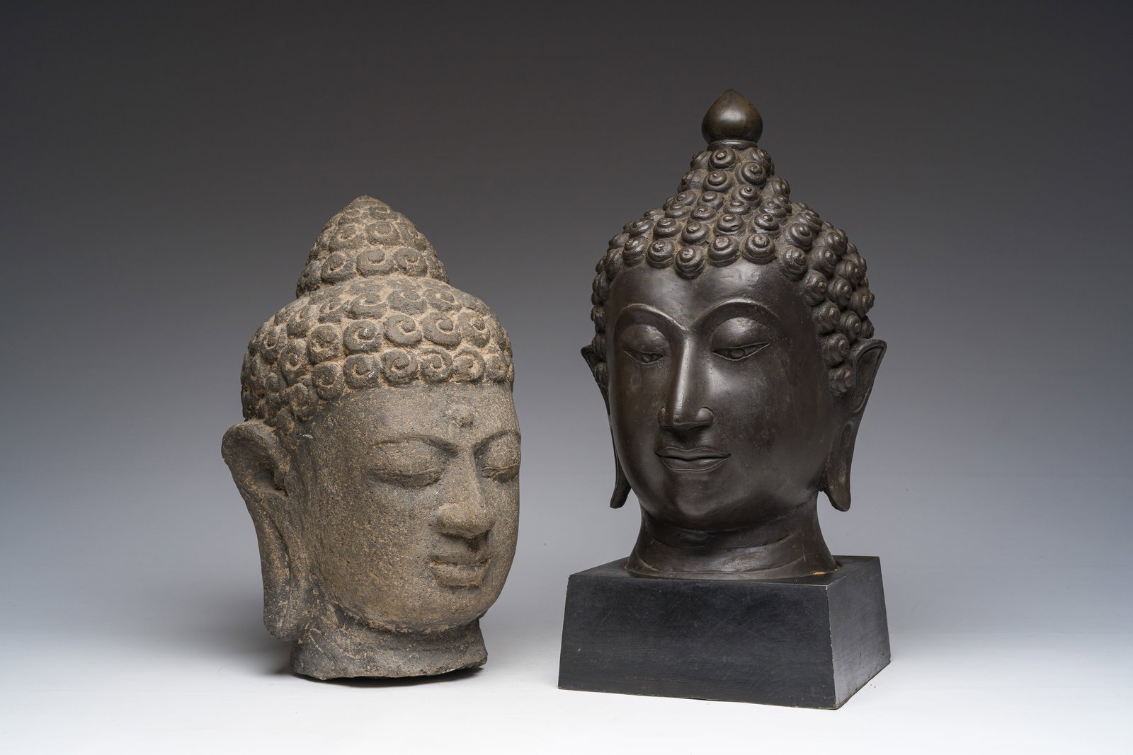 A Thai bronze Buddha head and a Chinese stone Buddha head, 19th/20th C. (1 of 7)