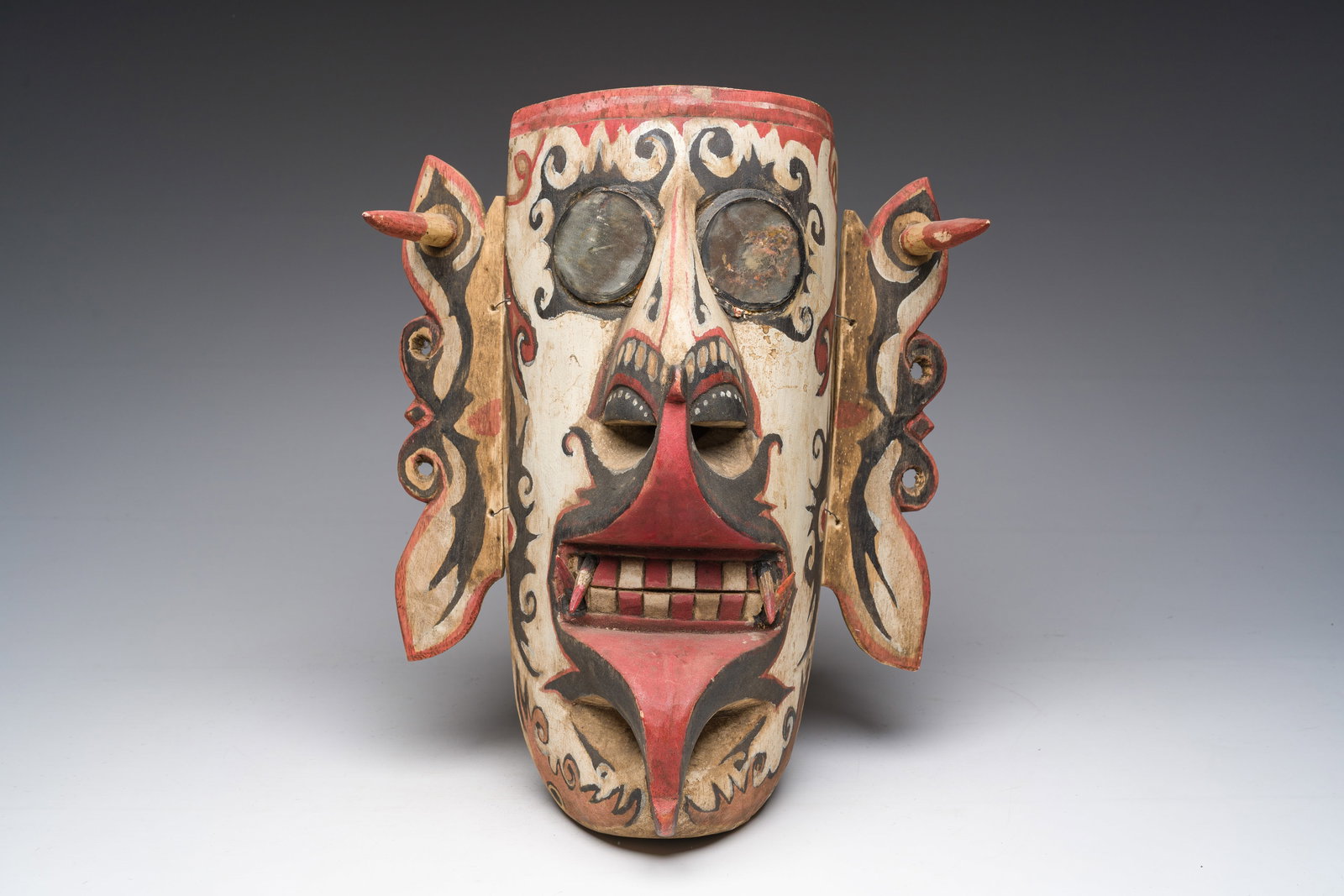 An Indonesian carved and polychrome decorated wooden Hudoq mask of the Dayak people with mirror (1 of 2)