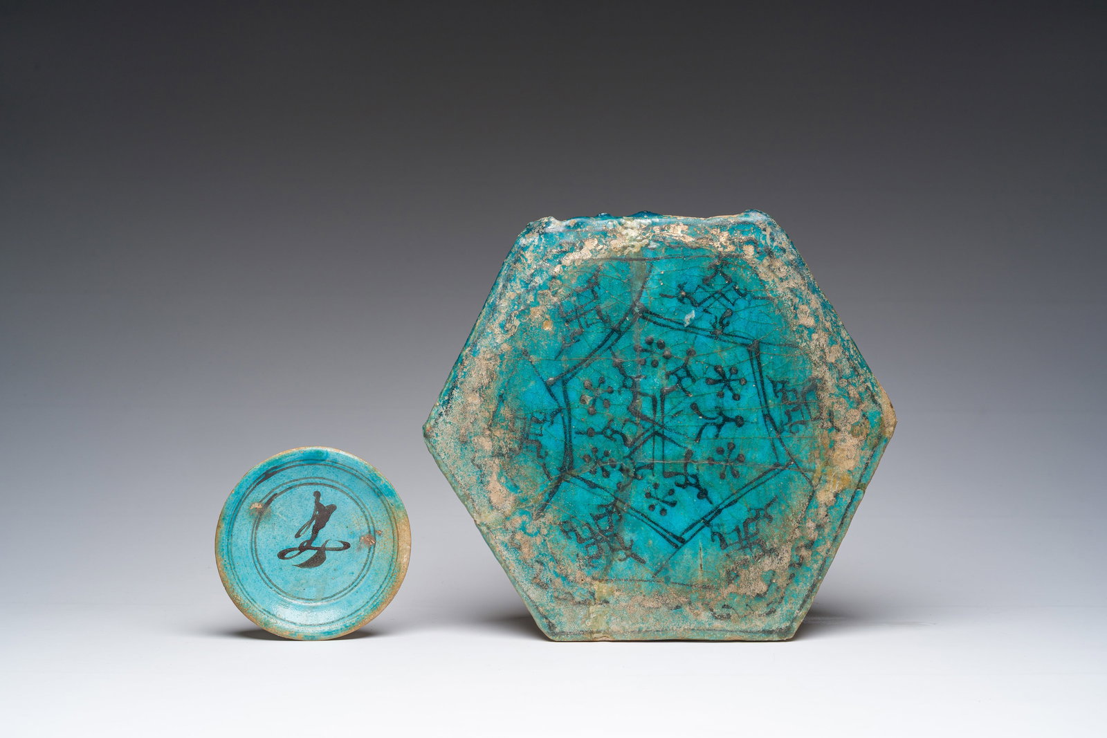 A hexagonal turquoise glazed Islamic tile and a calligraphic saucer, probably Damascus, Syria, 17th (1 of 2)