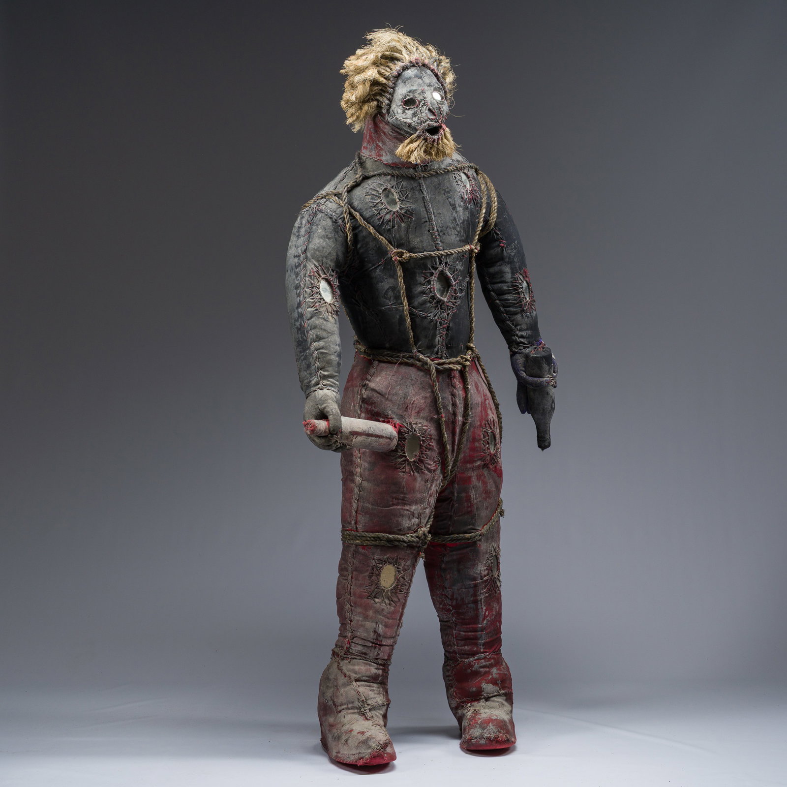 A Haitian Bizango sculpture of a hairy figure with a bottle in both hands, mixed media, 20th C. (1 of 8)