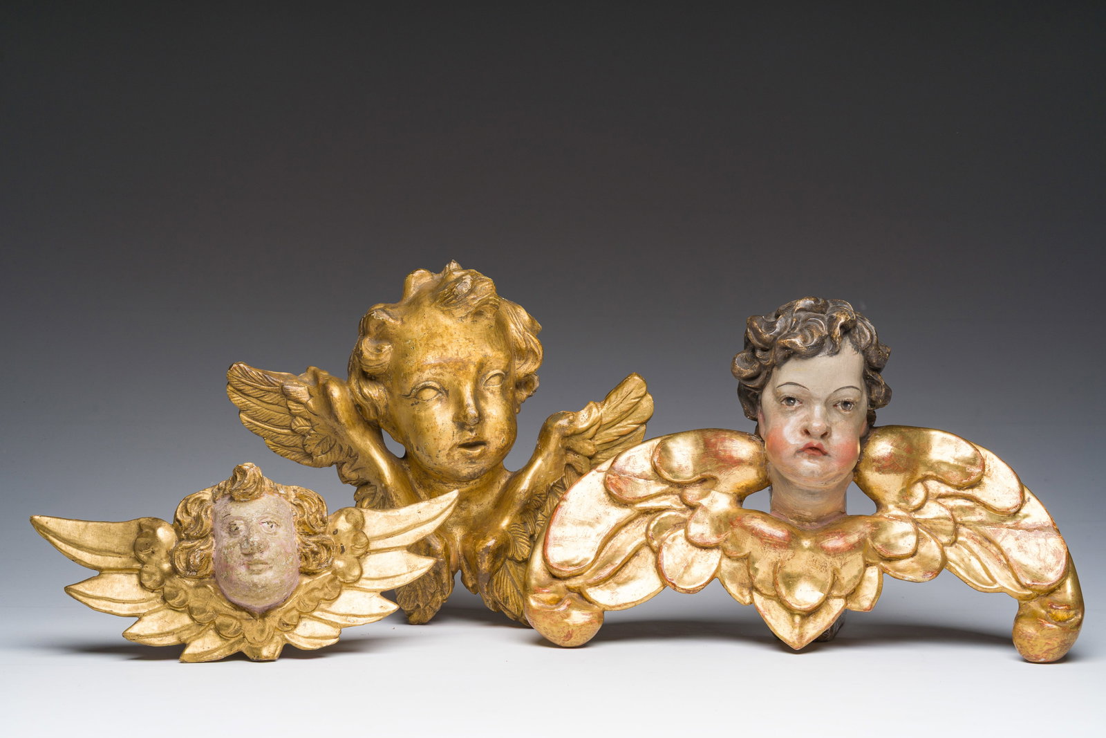 Three gilt and polychrome decorated wooden angel's heads, 18th C. (1 of 10)