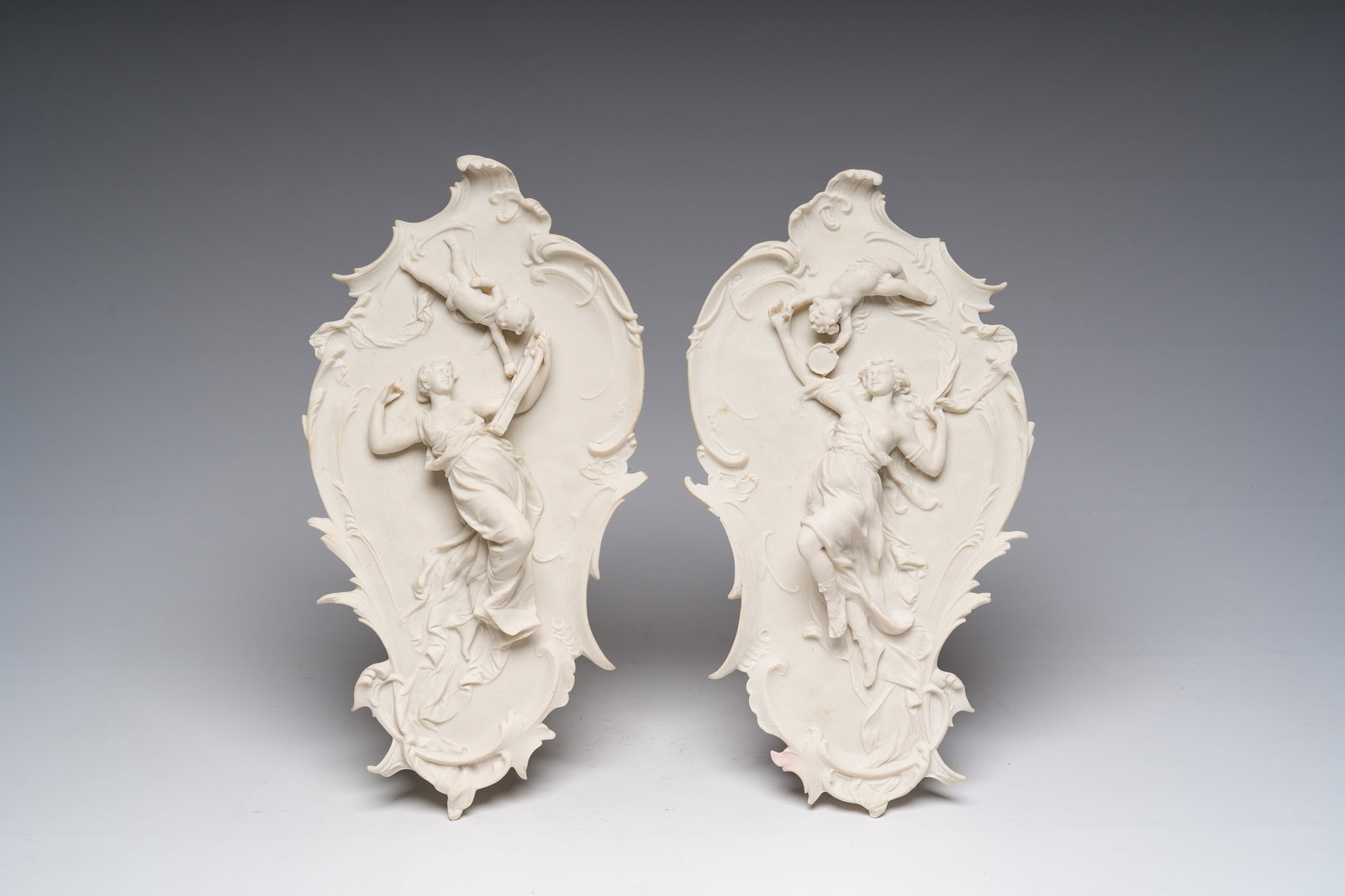 Enrico Braga (1841-1919, attributed to): A pair of Italian cast marble plaques with Cupid and Psyche: Enrico Braga (1841-1919, attributed to): A pair of Italian cast marble plaques with Cupid and Psyche in relief, 20th C. H 34 cm A medal set in the reverse with the text 'Perfugium Regibus'.