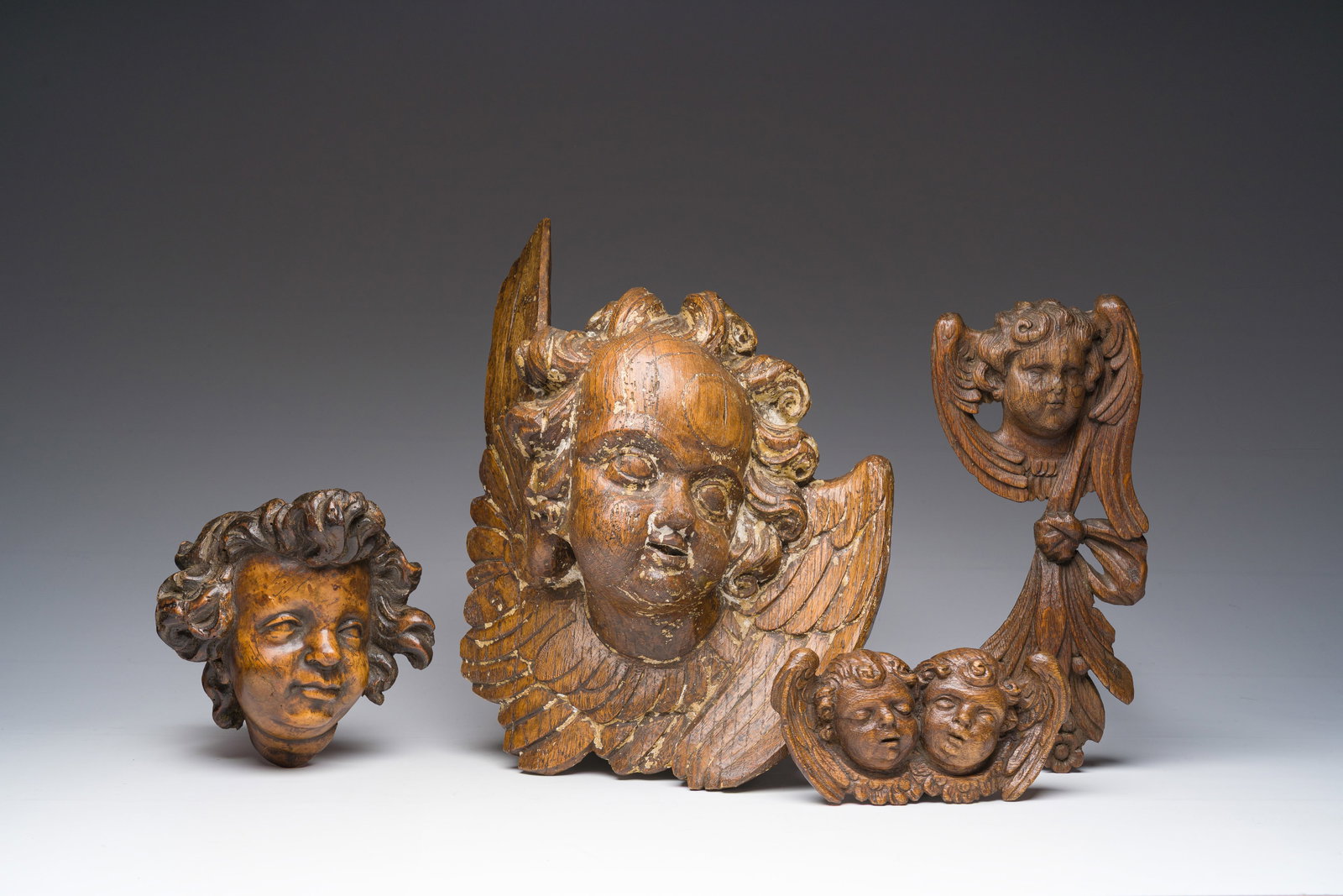 Four carved wooden angel heads, 17th C. and later: Four carved wooden angel heads, 17th C. and later H 37 - L 28 cm (the largest sculpture) H 9 - L 18 cm (the smallest sculpture)