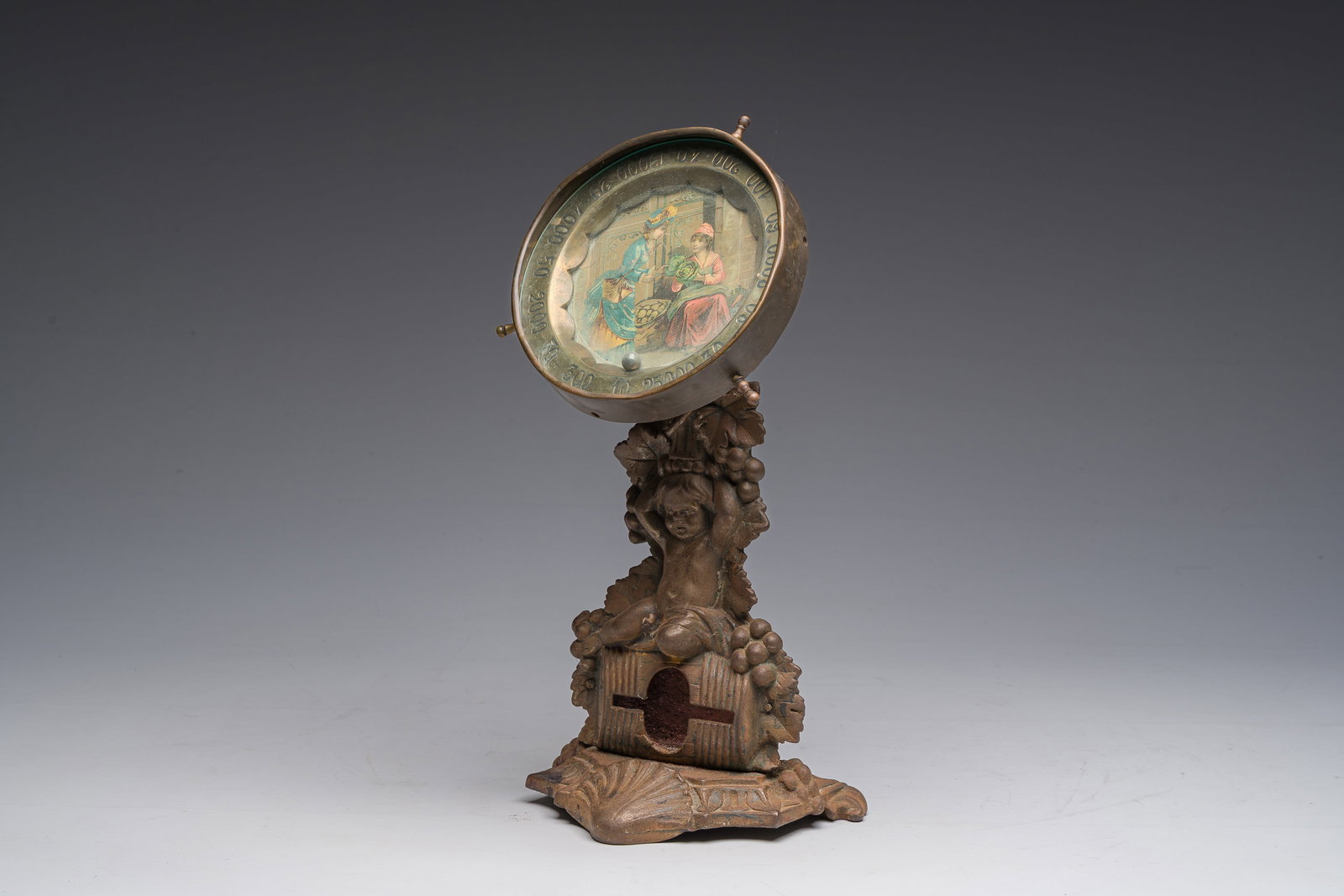 A brass roulette wheel decorated with a greengrocer and her customer on a metal stand with Bacchus (1 of 7)