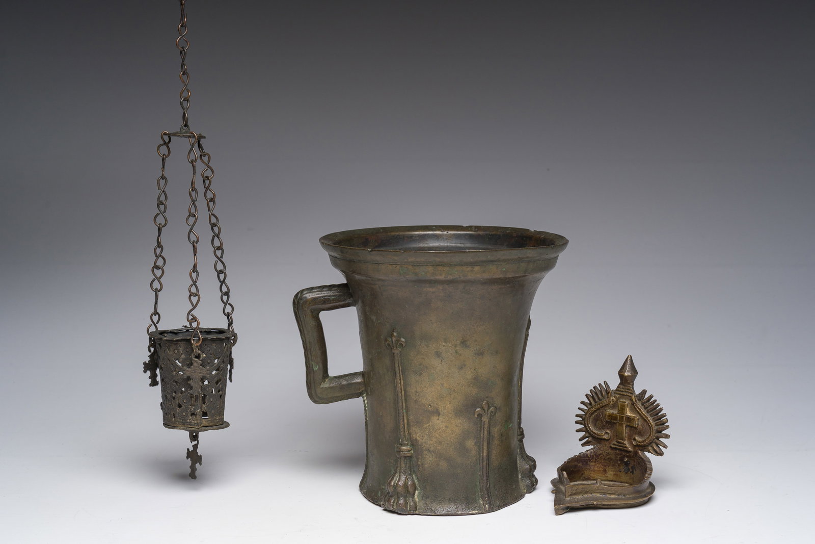 A presumably Nuremberg bronze mortar with lilies, a diya and a lamp holder, 15th C. and later (1 of 8)