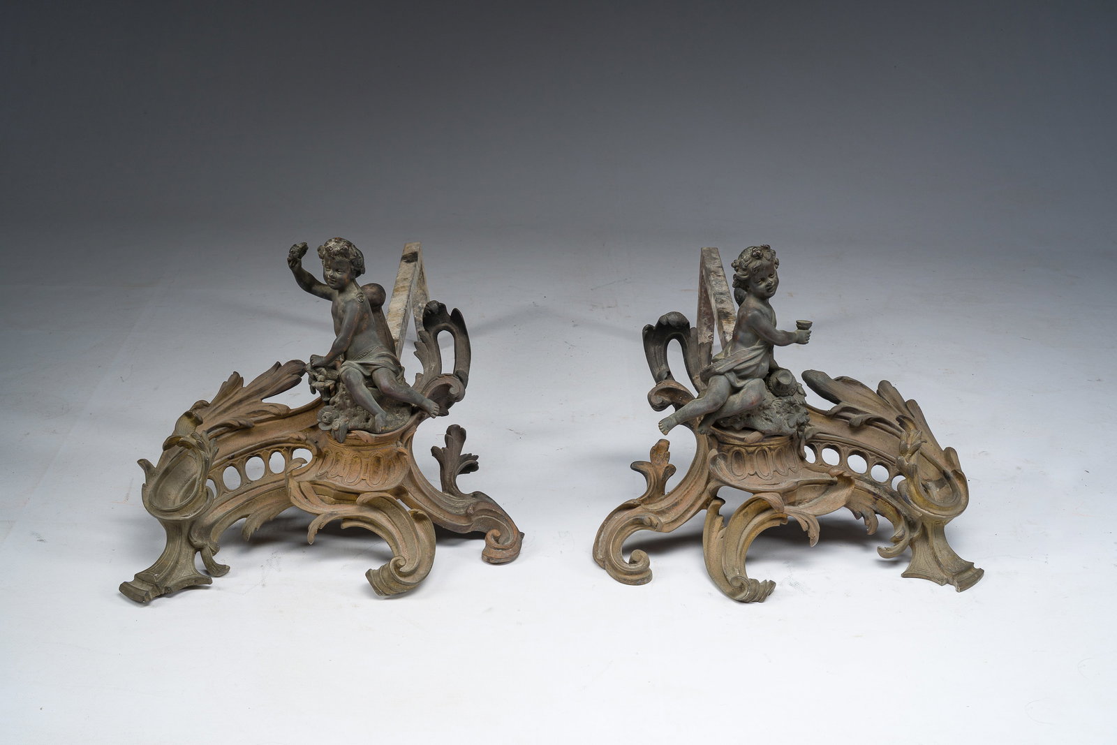 A pair of French Louis XV style partly gilt and patinated bronze andirons with a putto, ca. 1900 (1 of 8)