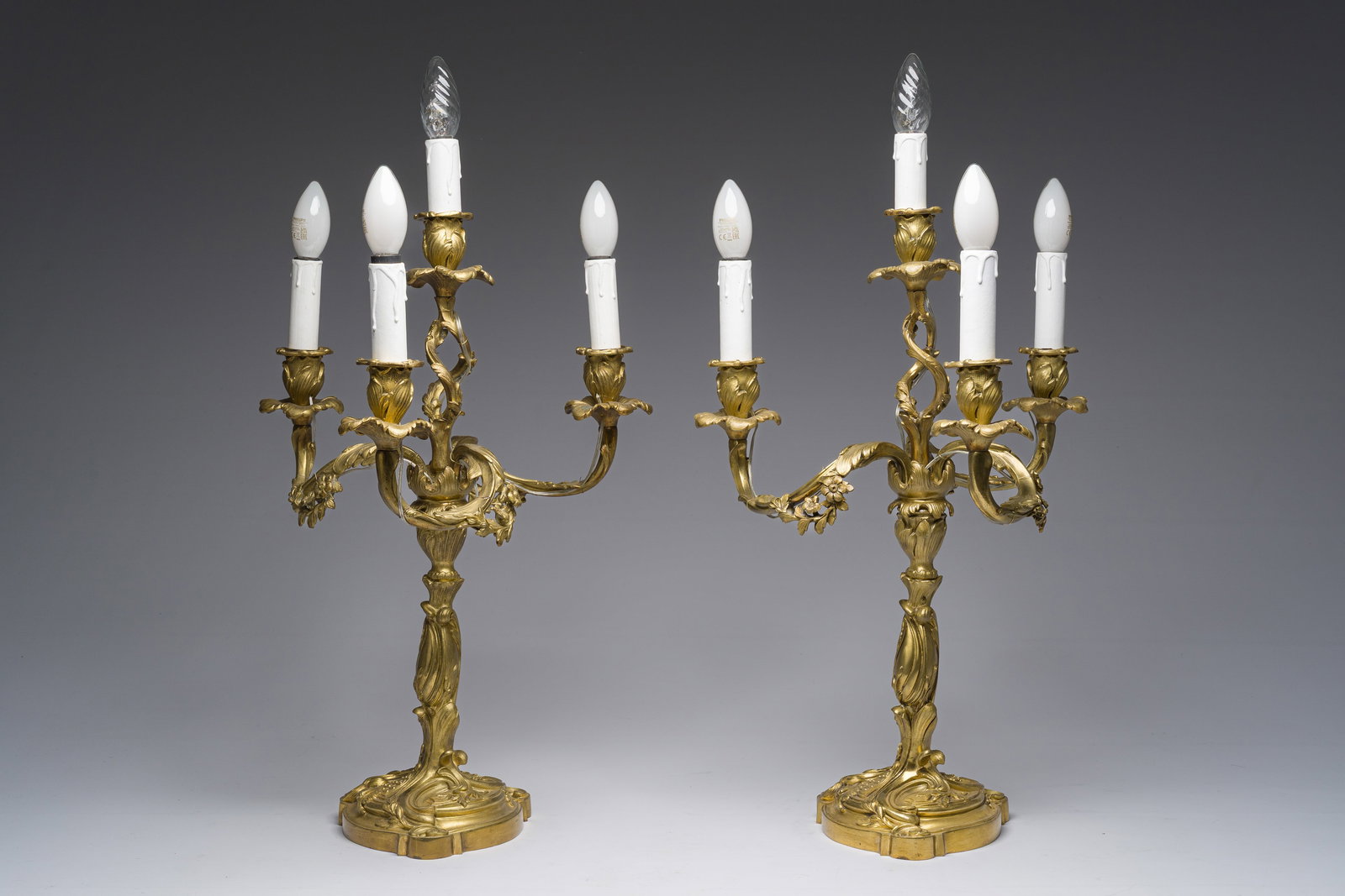 A pair of French Louis XV style gilt bronze four-light candlesticks with floral relief design, (1 of 6)