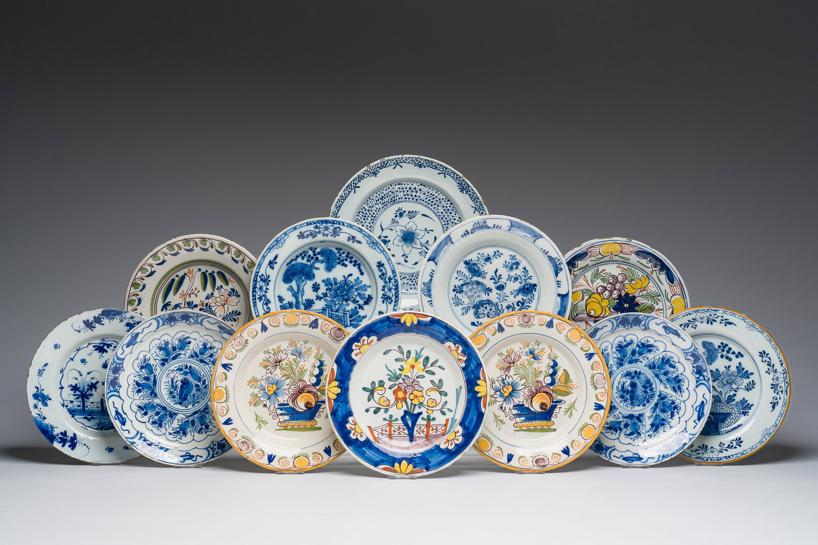 Twelve blue, white and polychrome Dutch Delft plates and dishes with floral design, 18th C. (1 of 7)