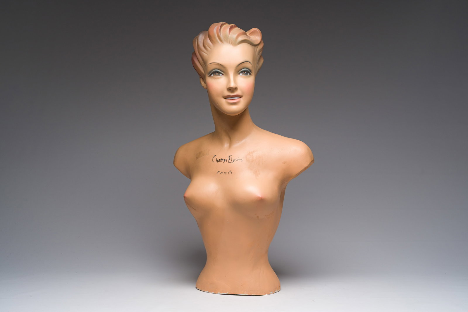 A French polychrome painted plaster female mannequin bust, marked 'Champs Elysees Paris', 20th C. (1 of 10)