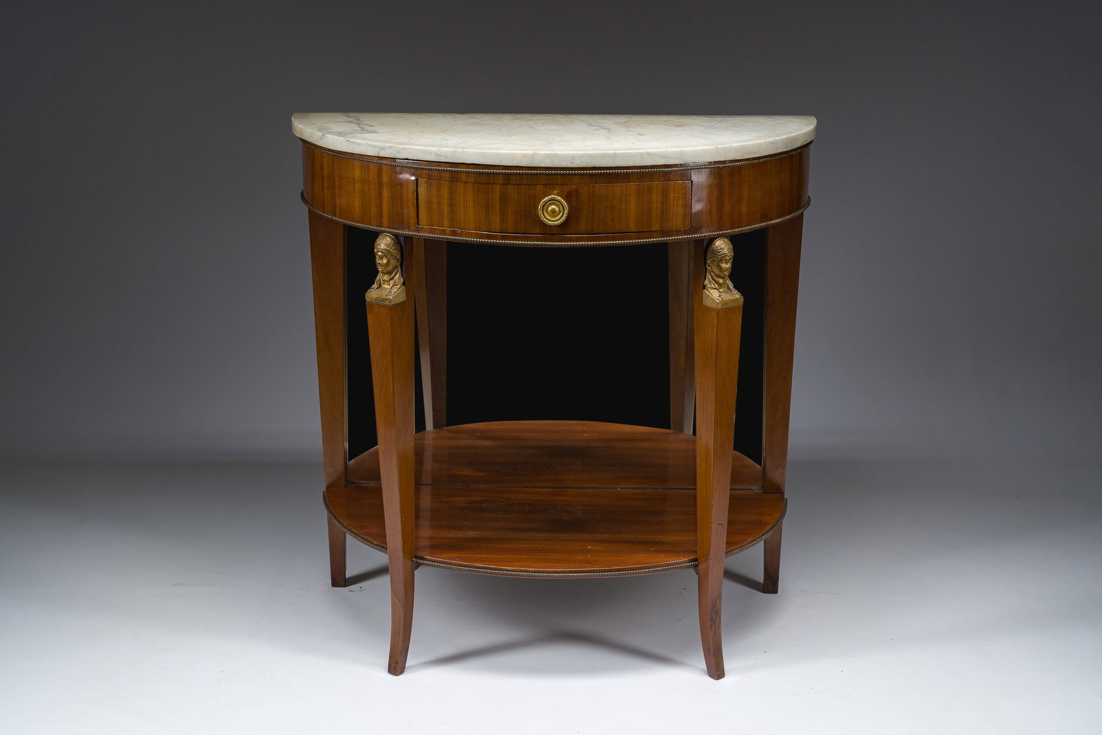 Georges Jacob (1739–1814): A French Empire gilt bronze mounted mahogany wooden demi-lune console: Georges Jacob (1739–1814): A French Empire gilt bronze mounted mahogany wooden demi-lune console with a drawer and a white marble top H 89,5 - L 92 - D 46,5 cm The stamp of G. Jacob is present under