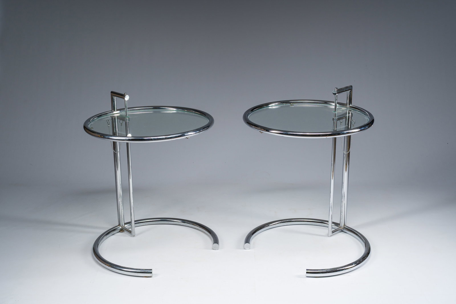 Eileen Gray (1878-1976): A pair of height-adjustable chromed steel and glass side tables, the (1 of 11)