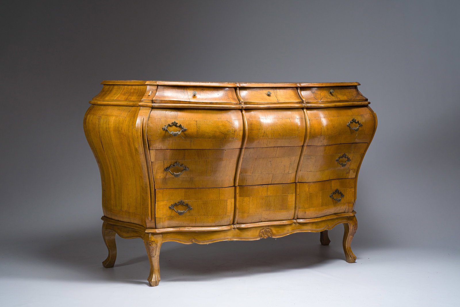An Italian bombe olive wooden veneered chest of drawers, 20th C. (1 of 6)