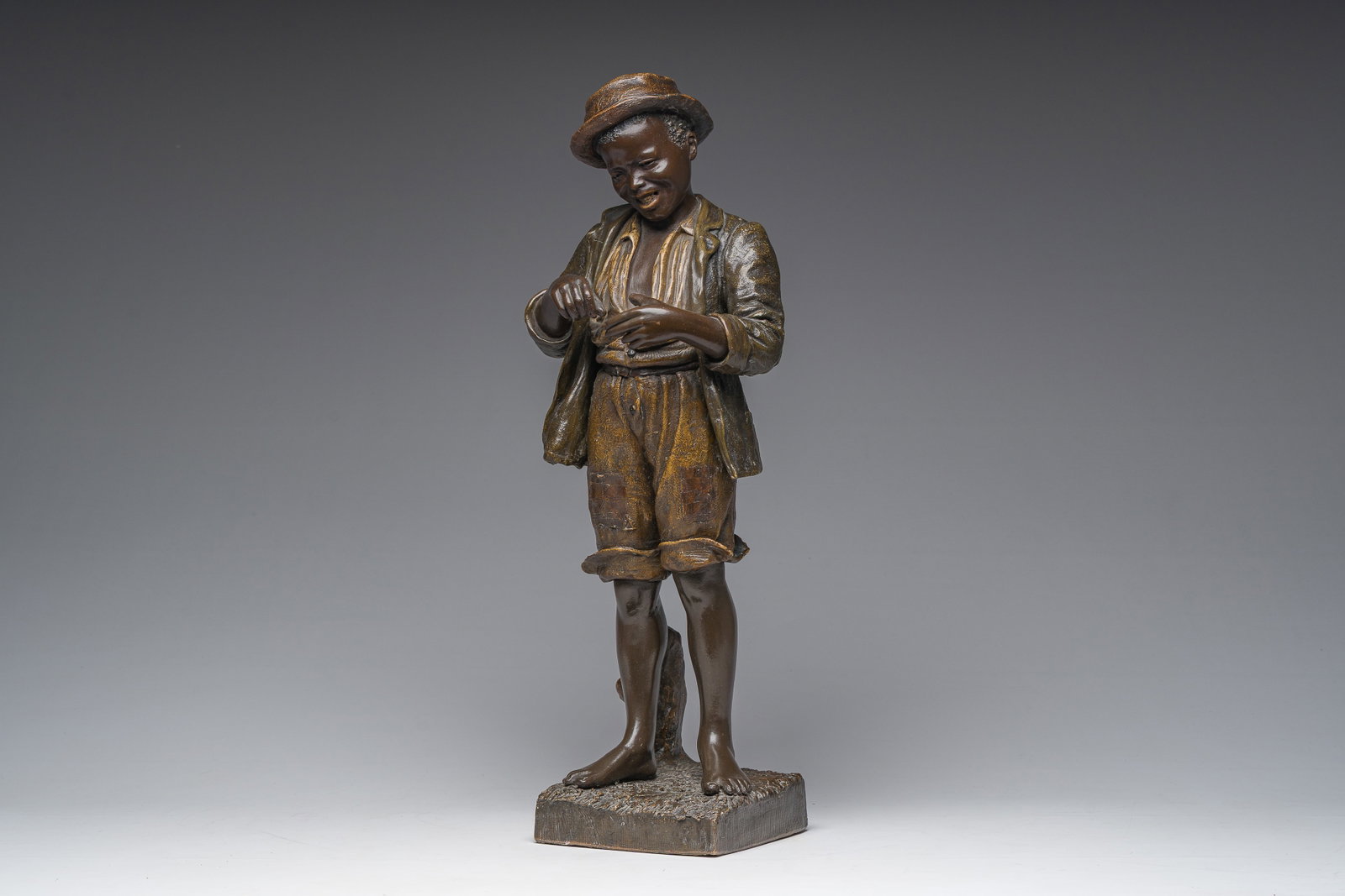 Cherc for Goldscheider (Hans Schörk (1849-1899), after): A polychrome decorated terracotta: H 59,5 cm The reverse marked 'Friedrich Goldscheider Wien' and 'Reproduction Reservée' and numbered '1471, '170 and '29'. Ref.: - Based on a painted pottery model of a young boy, ca. 1910, by C