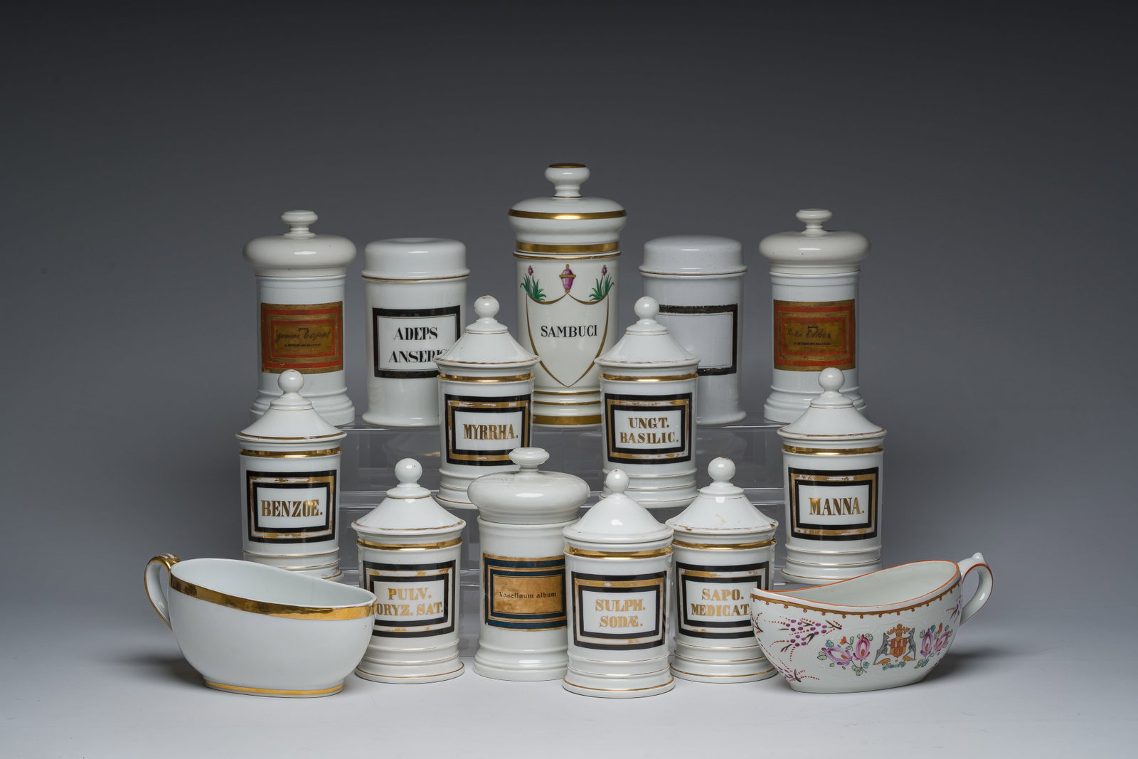Thirteen Belgian and French gilt and polychrome decorated porcelain pharmacy jars and two: L 25 - 23 cm (the bourdalous) H 24,5 - 19 cm (the tallest and the smallest pharmacy jar) Various marks and labels, a.o. 'Renaud et Tino à Paris', 'Ch. et G. Siegfried Fils à Strasbourg',