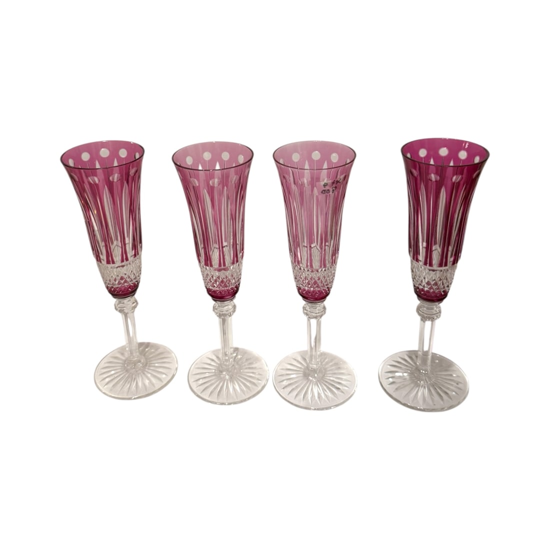 Set of 4 Saint-Louis Tommy Amethyst Cut-to-Clear Crystal Champagne Flutes: A refined set of four Saint-Louis “Tommy” pattern champagne flutes in the desirable amethyst cut-to-clear crystal coloration. Each glass features the iconic Tommy design with vertical and diam