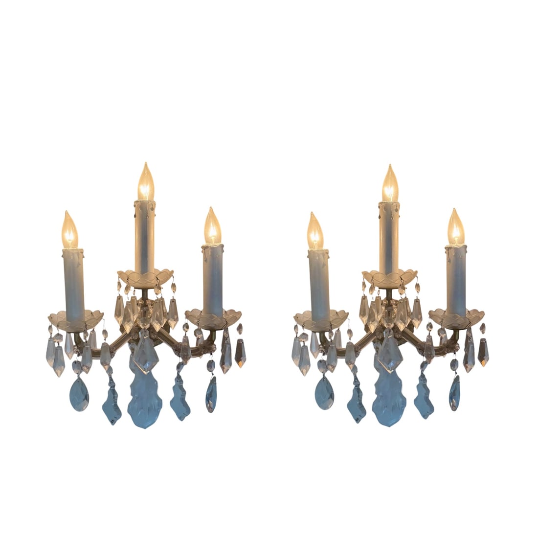 Pair of Vintage Maria Theresa Style Crystal Wall Sconces: Elegant pair of vintage Maria Theresa style wall sconces featuring an ornate metal frame adorned with faceted crystal drops and prisms. Each sconce has three candle-style lights with classic drip slee