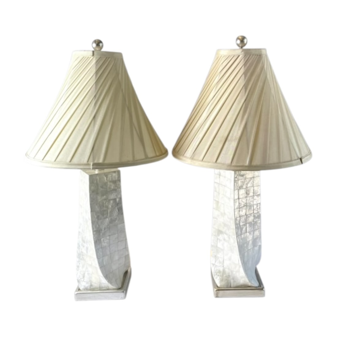 Pair of Mother-of-Pearl Mosaic Table Lamps: Decorative pair of matching table lamps featuring tall, sculptural bodies covered in iridescent mother-of-pearl-style mosaic tiles. Each lamp has a gently curved rectangular form, a silver-tone base, 