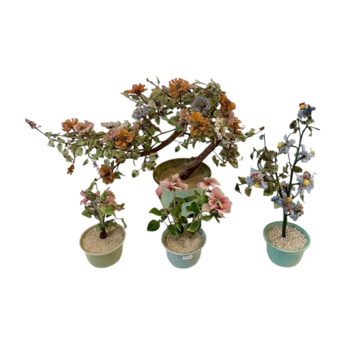Four Chinese Hardstone Floral Bonsai Trees: Collection of four vintage Chinese decorative flowering bonsai sculptures, composed of carved hardstone and glass elements secured to wrapped wire branches. Each arrangement is planted in a celadon-gl